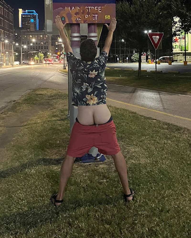 Photo recadrée d’un postérieur levé devant le panneau Downtown Dallas, de nuit.